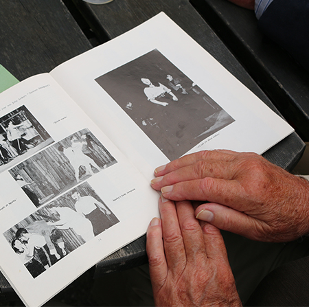 Hands placed on an old alumni magazine
