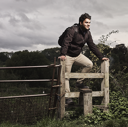 Student Azan climbing over a stile gate in the countryside