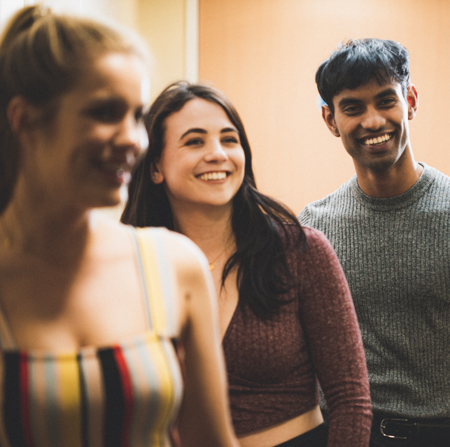 Three students standing in accommodation hallway