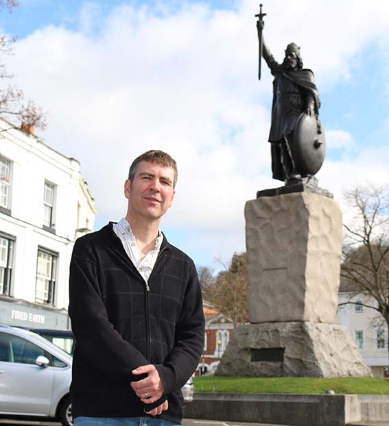 Man standing in front of King Alfred's statue in Winchester