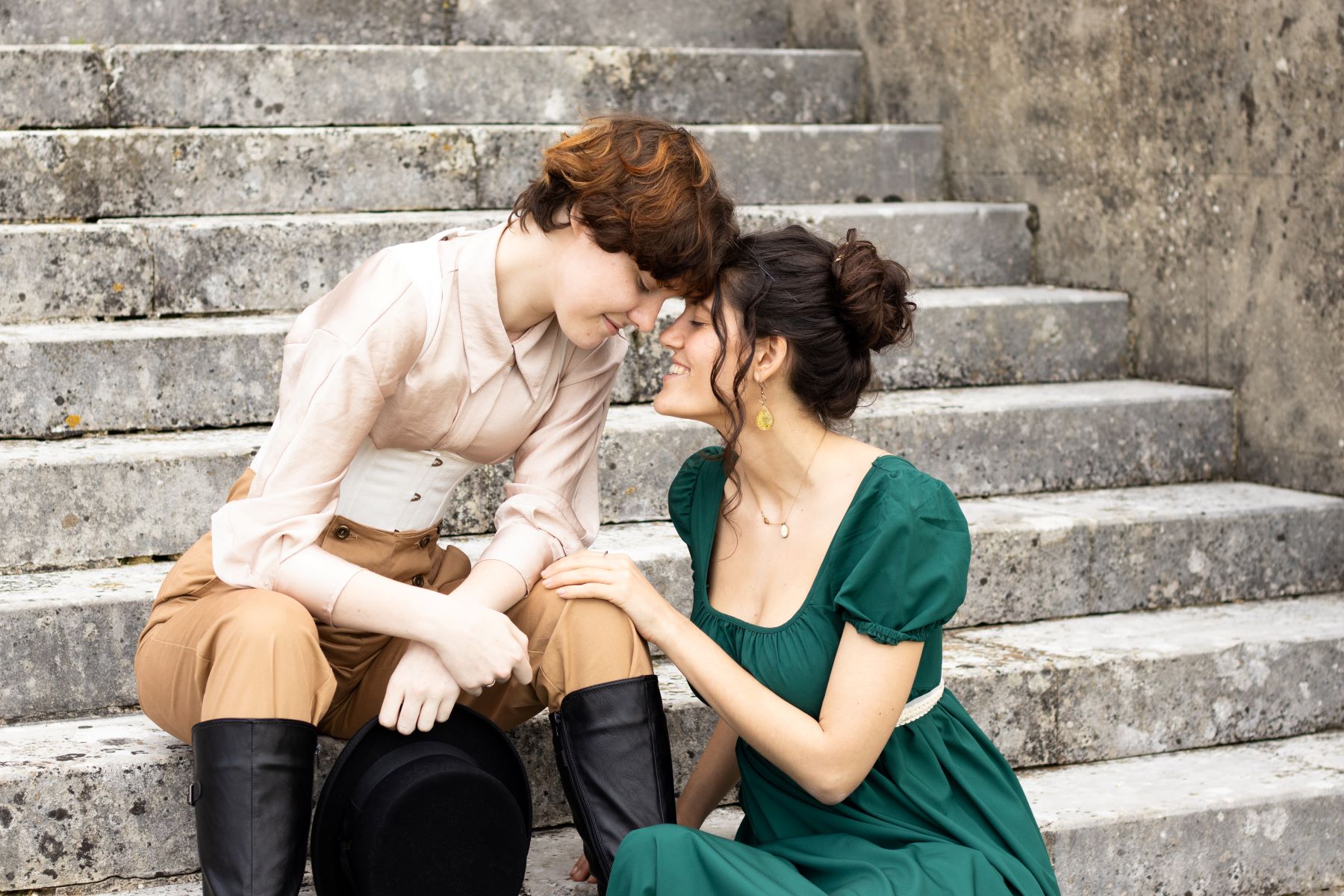 Regency couple sitting on steps with their heads together