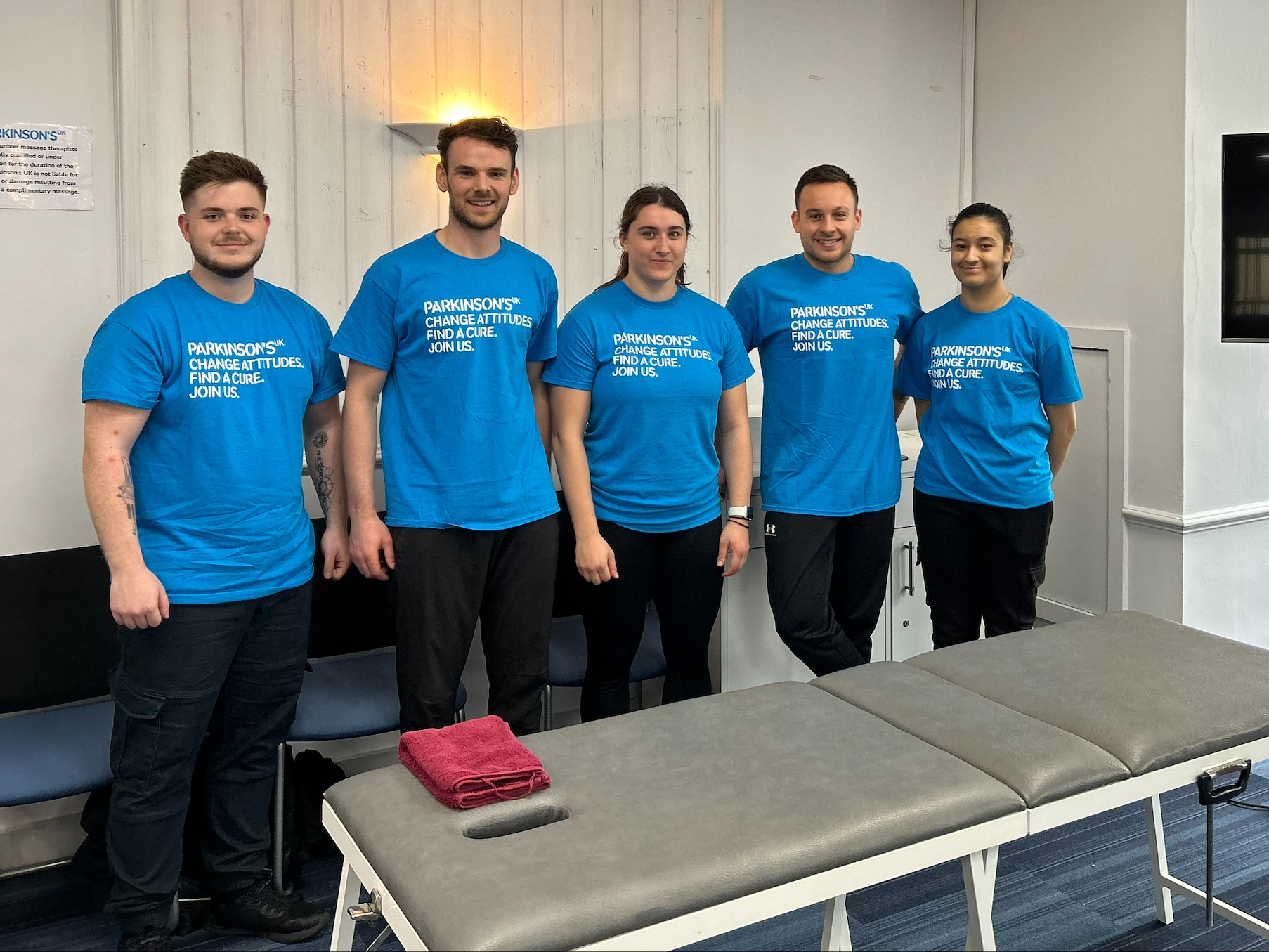 Line up of four physios in blue t-shirts