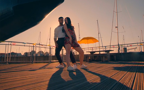 A man and woman dancing on decking at sunset