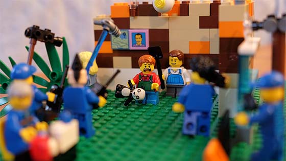 Lego display of child figure with teddy surrounded by cameras and film crew