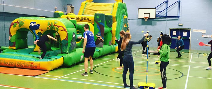 Students climb through inflatable obstacle course in sports hall