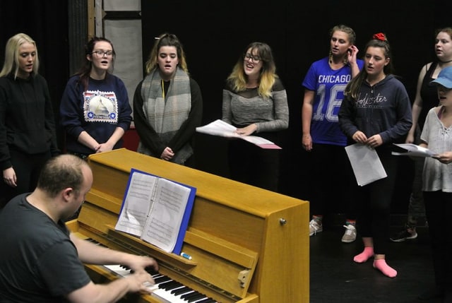 Musical theatre students singing by piano