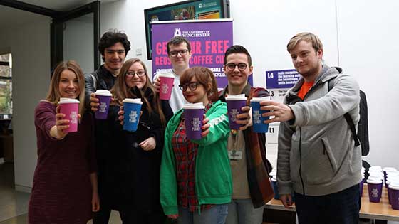 Volunteers holding Gumdrop re-useable coffee cups