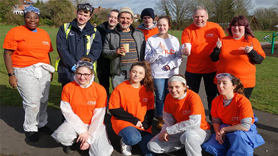 Volunteer group in orange tops smiling