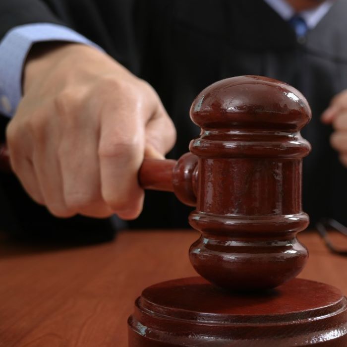 Close-up of hand holding judge's gavel