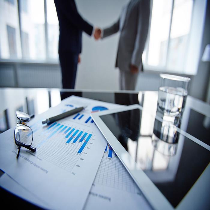 University of Winchester management accounting research: two business people shaking hands behind a desk