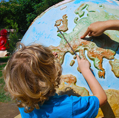 Education expertise at Winchester: child pointing at a place on a miniature planet