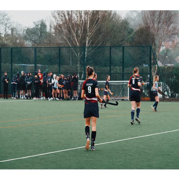 A hockey player at a match on an all weather pitch