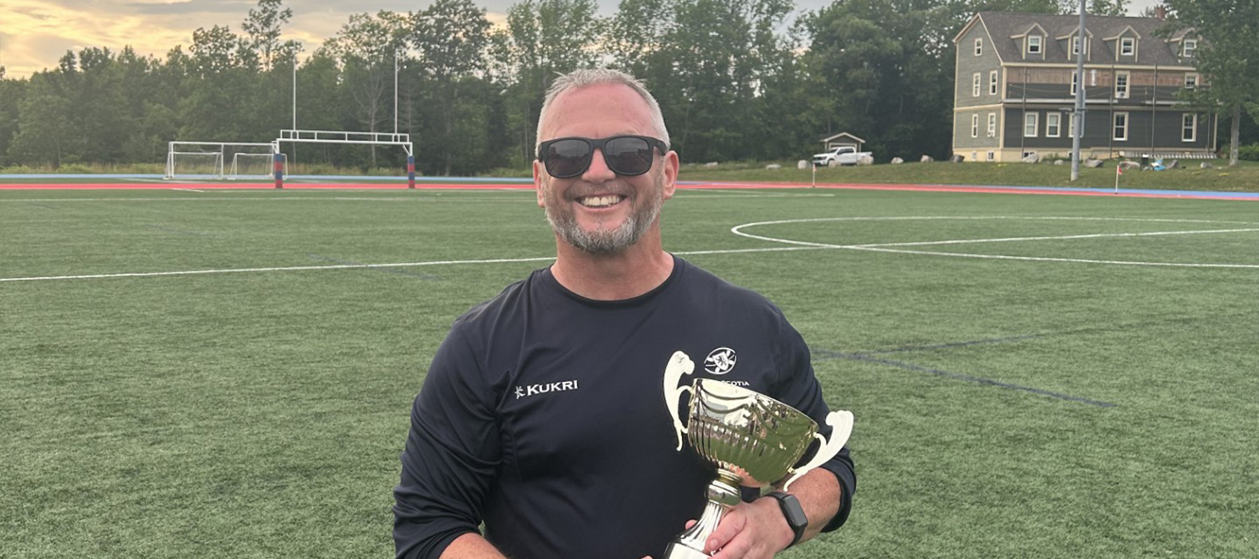 Dr James Alder with a sports trophy