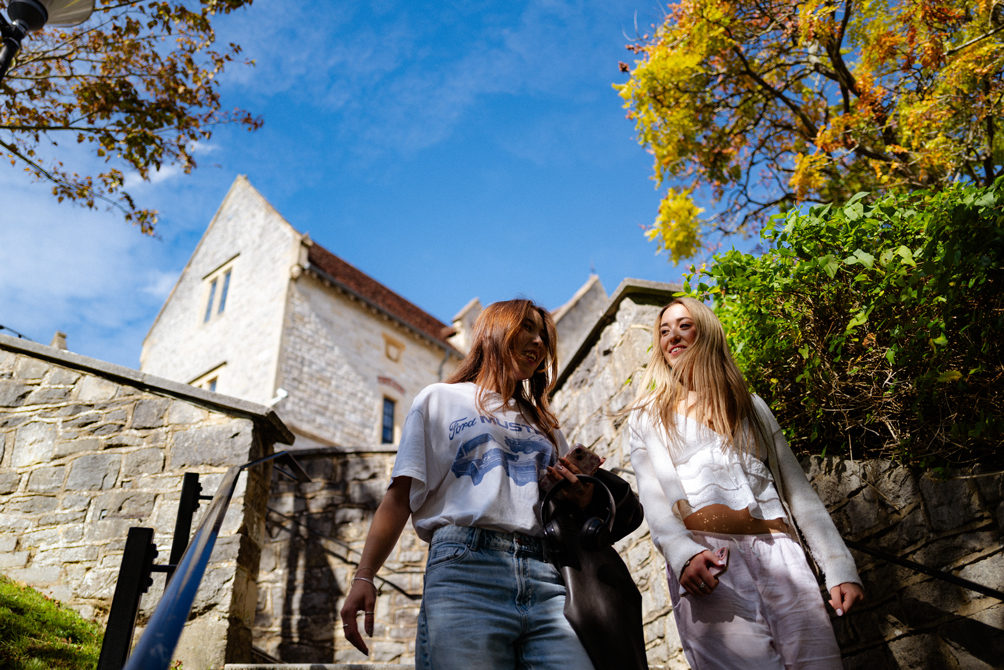 Two students walk down steps