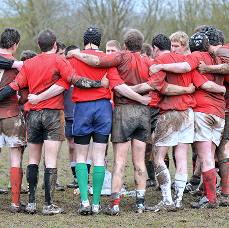 Rugby team stood in a huddle