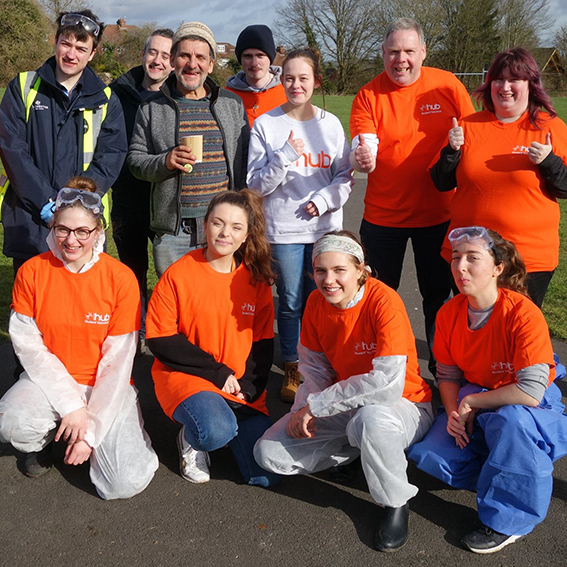 Group of student volunteers pose in orange t shirts