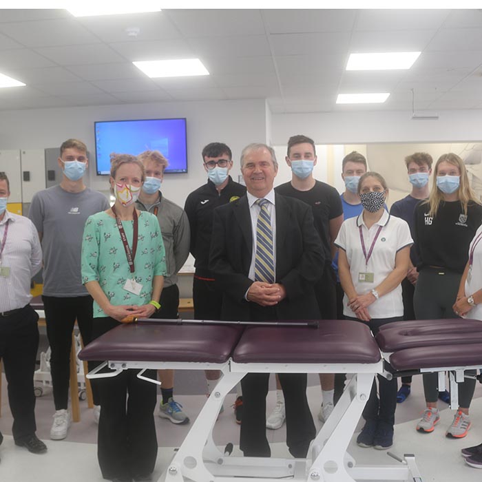 Sir Freddie standing in the centre of a group of Physiotherapy staff and students