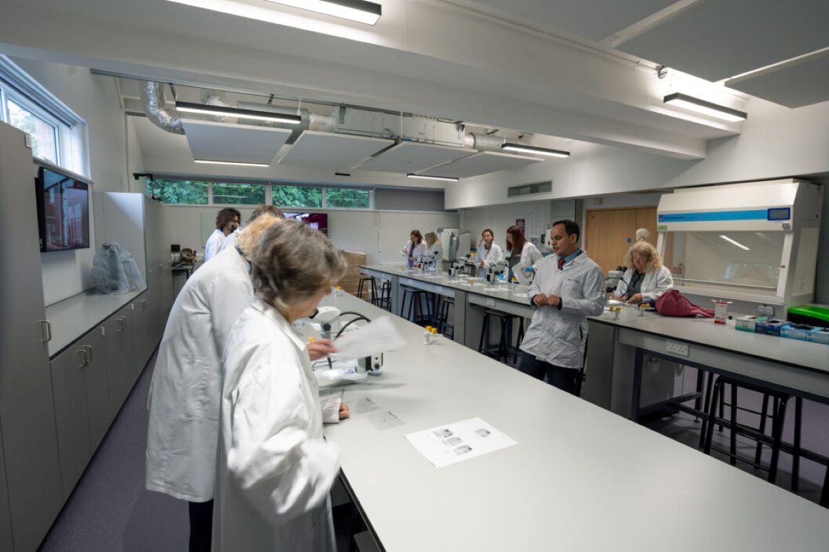 People in white coats working in a lab