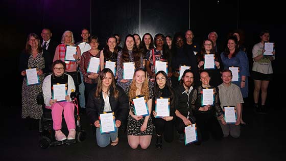 Group of volunteer champions standing together holding their awards