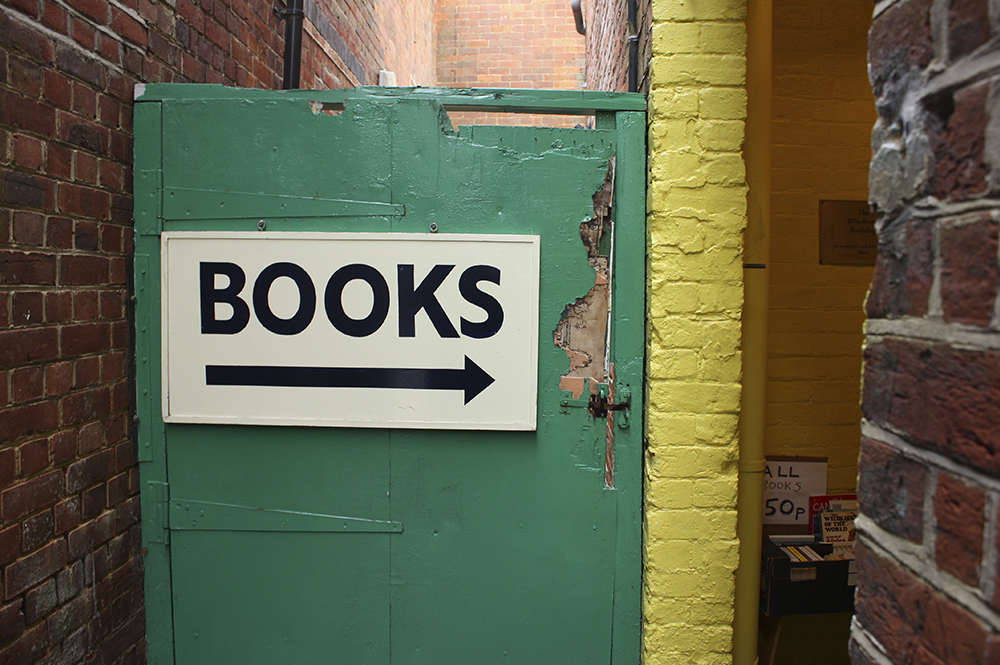 A sign reading 'BOOKS' on a door pointing right
