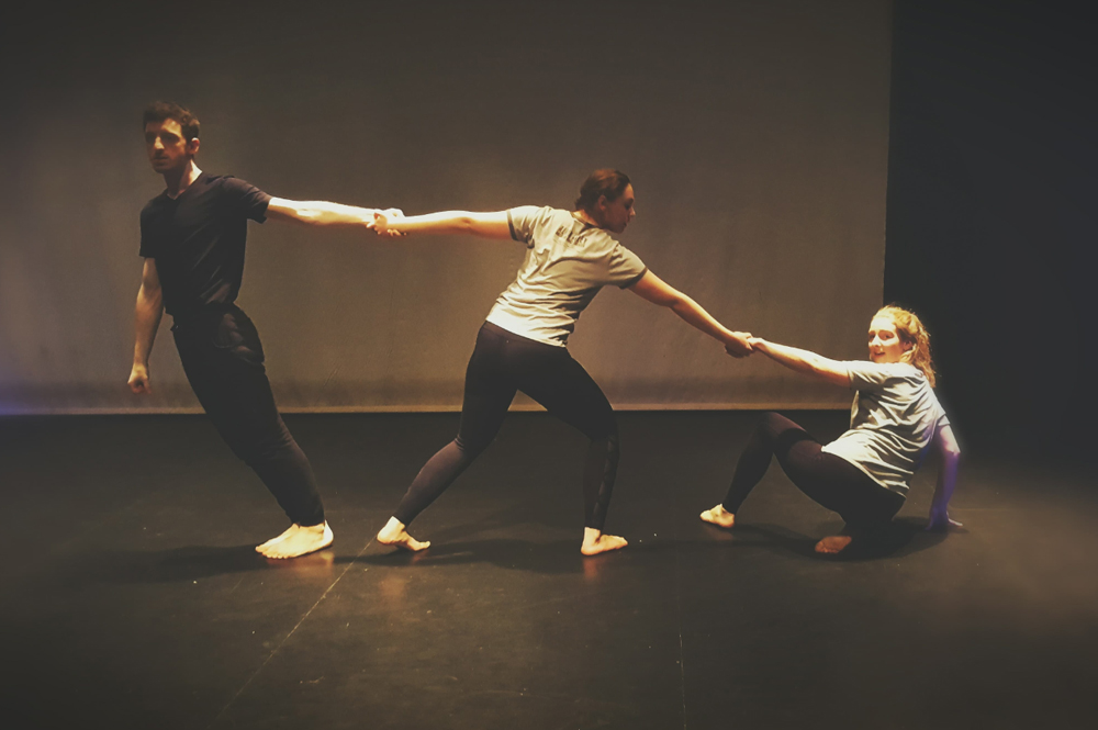 Group of three students dancing in a performance studio