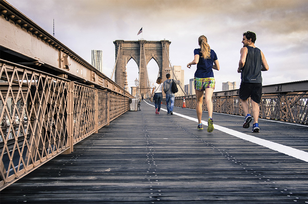 Man and women jogging on a bridge